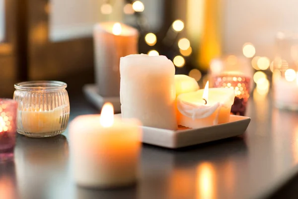 Candles burning on window sill with garland lights — Stock Photo, Image