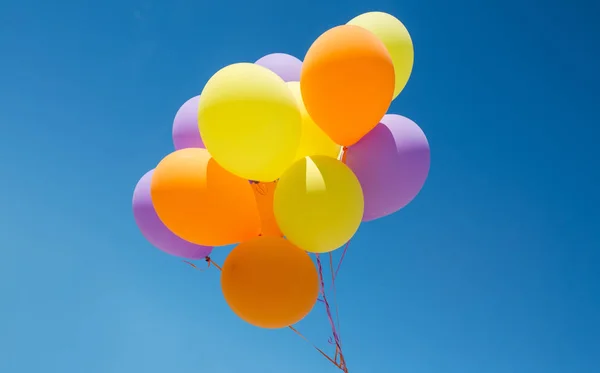 Primer plano de globos de helio de colores en el cielo azul — Foto de Stock