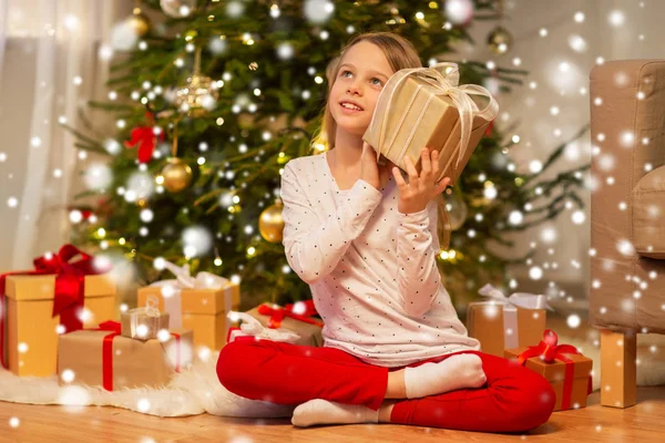 Menina sorridente com presente de Natal em casa — Fotografia de Stock