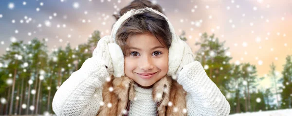 Petite fille portant des cache-oreilles sur la forêt d'hiver — Photo