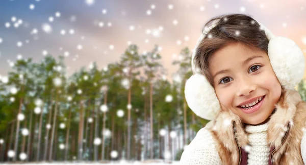 Liten flicka bära hörselkåpor över vintern skog — Stockfoto