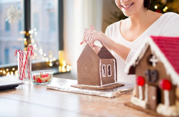Kvinna att göra pepparkakshus på jul — Stockfoto