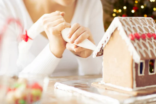 Vrouw maken van peperkoek huis op Kerstmis — Stockfoto