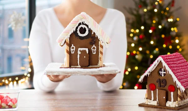 Close up van vrouw met kerst peperkoek huis — Stockfoto