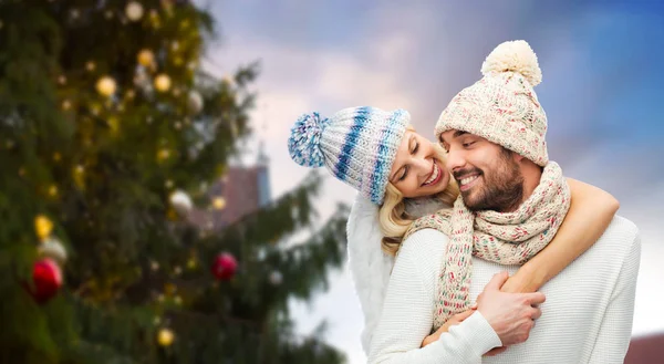 Feliz pareja abrazándose sobre el árbol de Navidad — Foto de Stock