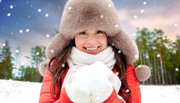 Mulher em chapéu de pele com neve sobre a floresta de inverno — Fotografia de Stock