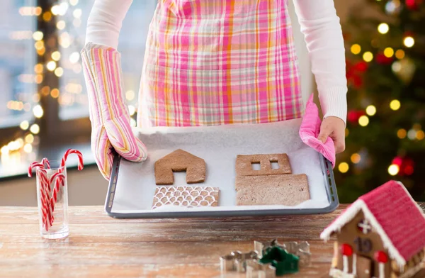 妇女与姜饼房子零件在烤箱托盘 — 图库照片