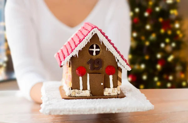 Close up of woman with christmas gingerbread house — Stock Photo, Image