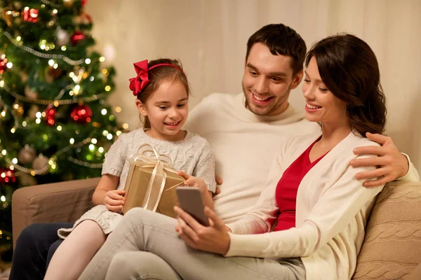 Familj med smartphone hemma på jul — Stockfoto