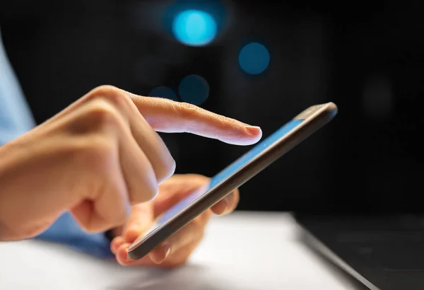 Nahaufnahme der Hände mit Smartphone im Nachtbüro — Stockfoto