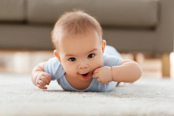 Söt liten asiatisk pojke liggande på golvet hemma — Stockfoto