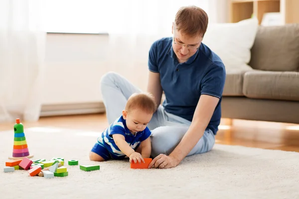 Pai feliz com bebê filho brincando de brinquedos em casa — Fotografia de Stock