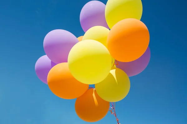 Perto de balões de hélio coloridos no céu azul — Fotografia de Stock