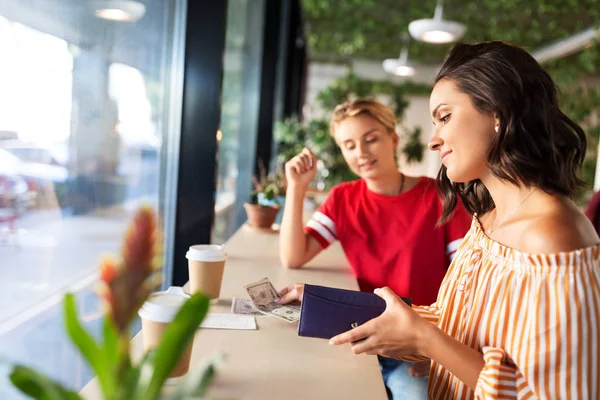 Female friends paying for coffee at cafe — Stock Photo, Image