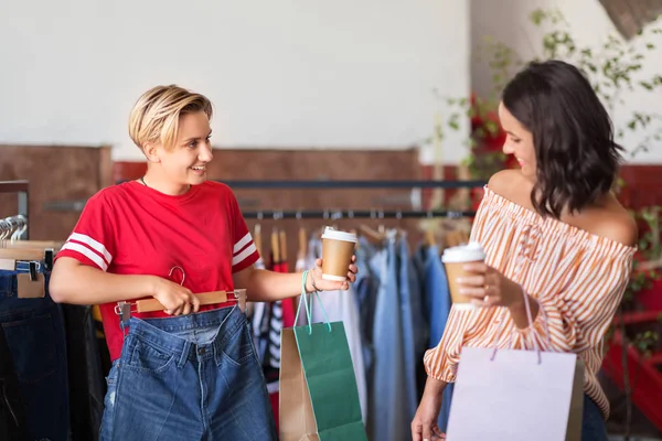 Mulheres felizes com café na loja de roupas vintage — Fotografia de Stock