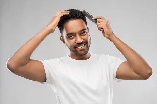 Glücklicher indischer Mann, der Haare mit Kamm bürstet — Stockfoto