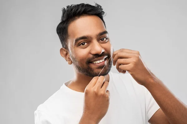 Uomo indiano con denti di pulizia filo interdentale — Foto Stock