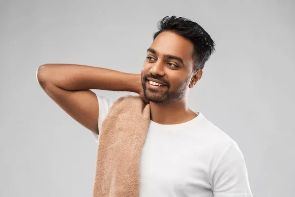 Uomo indiano sorridente con asciugamano su sfondo grigio — Foto Stock