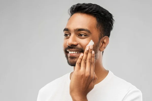 Felice uomo indiano applicando crema per il viso — Foto Stock