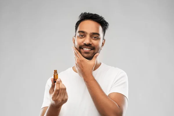 Улыбающийся индиец, намазывающий бороду растительным маслом — стоковое фото