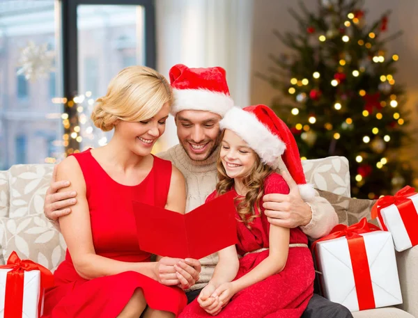 Lycklig familj läsa jul gratulationskort — Stockfoto