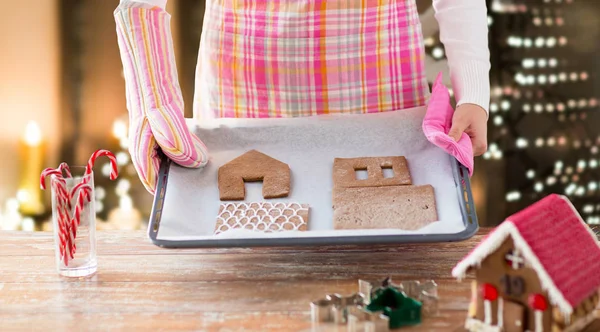 Gingerbread house bölümleri fırın tepsisindeki kadınla — Stok fotoğraf