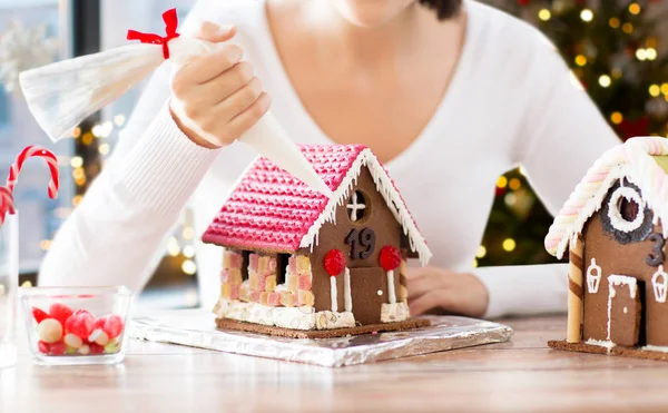 Woman making gingerbread houses on christmas — Stock Photo, Image