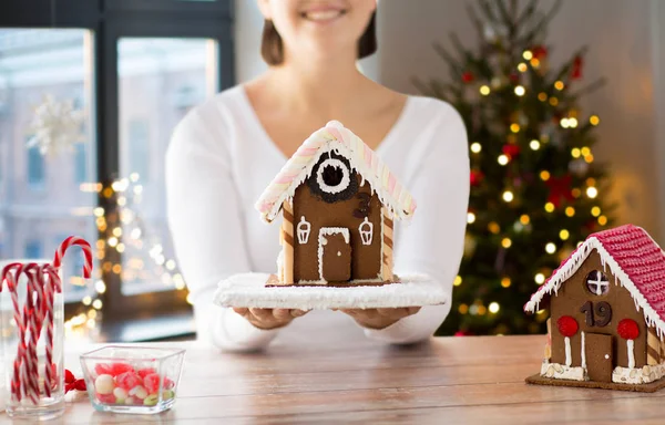 Primer plano de la mujer con la casa de jengibre de Navidad —  Fotos de Stock