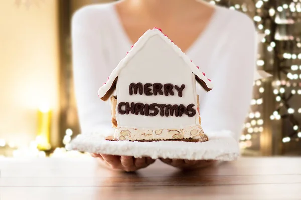 Primer plano de la mujer con la casa de jengibre de Navidad —  Fotos de Stock