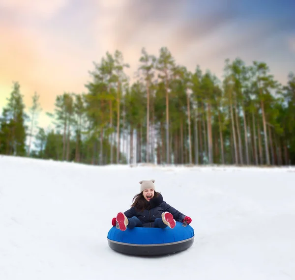 Felice ragazza adolescente scorrevole giù collina sul tubo della neve — Foto Stock