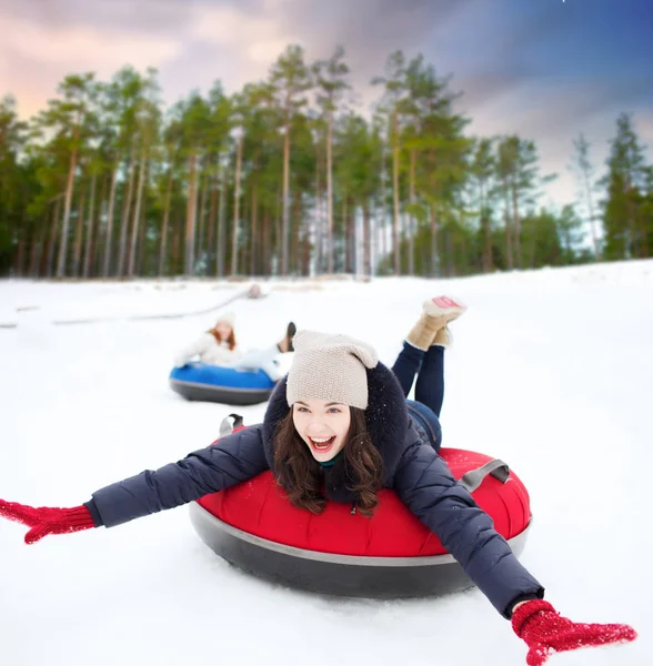 Menina adolescente feliz deslizando para baixo colina no tubo de neve — Fotografia de Stock