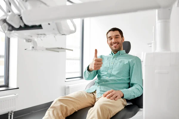 Paciente sorrindo mostrando polegares para cima na clínica odontológica — Fotografia de Stock