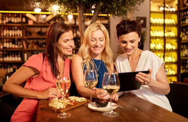 Women with tablet pc at wine bar or restaurant — Stock Photo, Image