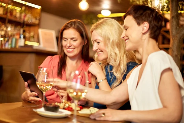 Women with tablet pc at wine bar or restaurant — Stock Photo, Image