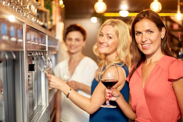 Happy women drinking wine at bar or restaurant — Stock Photo, Image