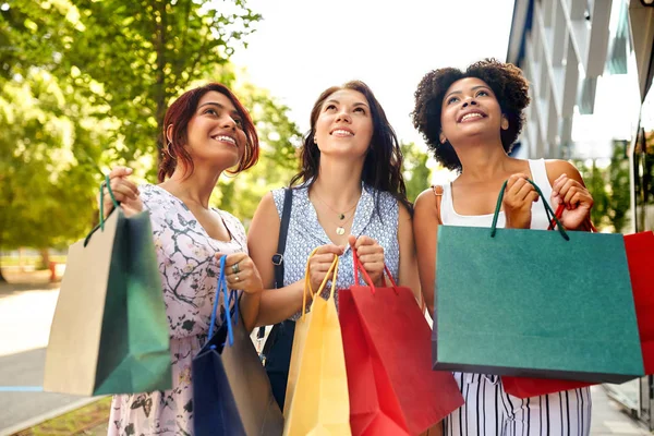 Gelukkig vrouwen met boodschappentassen in stad — Stockfoto