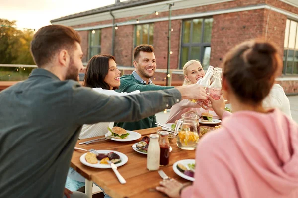 Happy friends toasting drinks at rooftop party — Stock Photo, Image