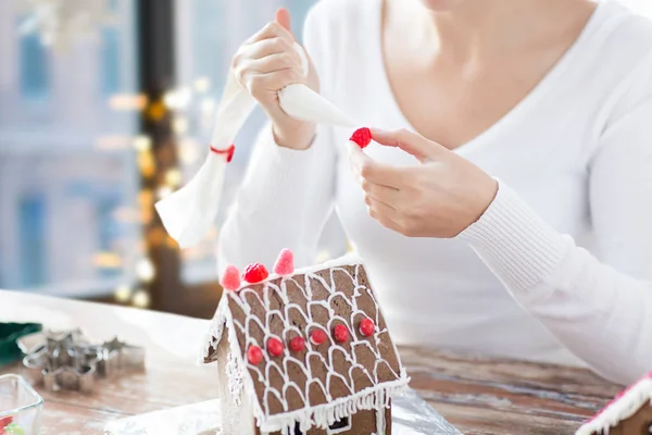 Close up van vrouw maken van peperkoek huis — Stockfoto