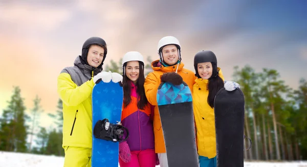 Glückliche Freunde in Helmen mit Snowboards im Freien — Stockfoto