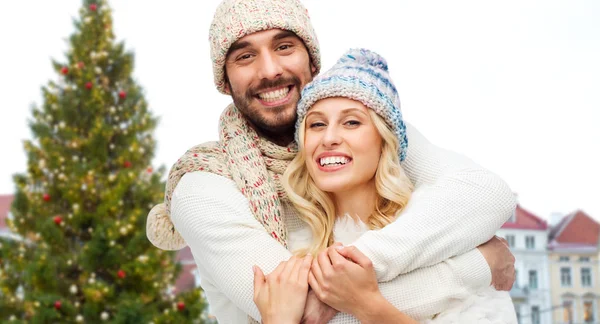 Feliz pareja abrazándose sobre el árbol de Navidad —  Fotos de Stock