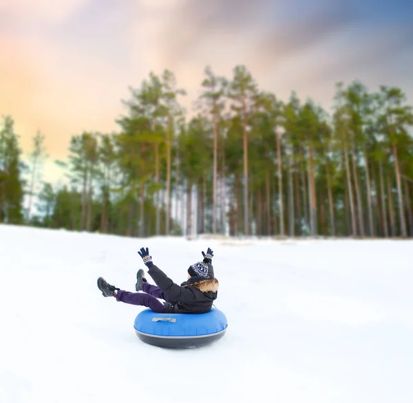 Happy young man sliding down hill on snow tube — Stock Photo, Image