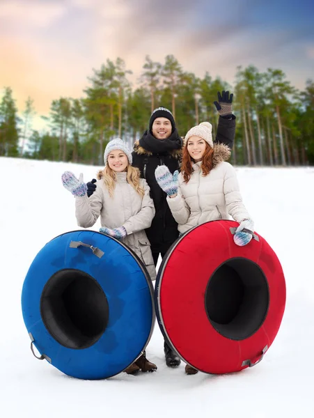 Amigos felices con tubos de nieve al aire libre en invierno —  Fotos de Stock