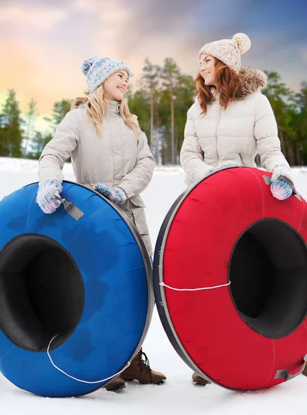 Happy teenage girls with snow tubes in winter — Stock Photo, Image