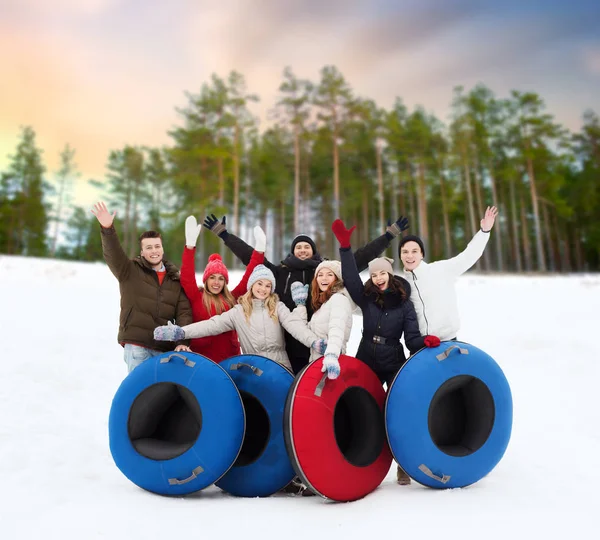 Amigos felizes com tubos de neve ao ar livre no inverno — Fotografia de Stock