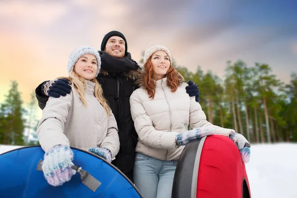 Amis heureux avec des tubes à neige à l'extérieur en hiver — Photo