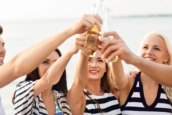 Amigos felices bebiendo cerveza sin alcohol en la playa —  Fotos de Stock