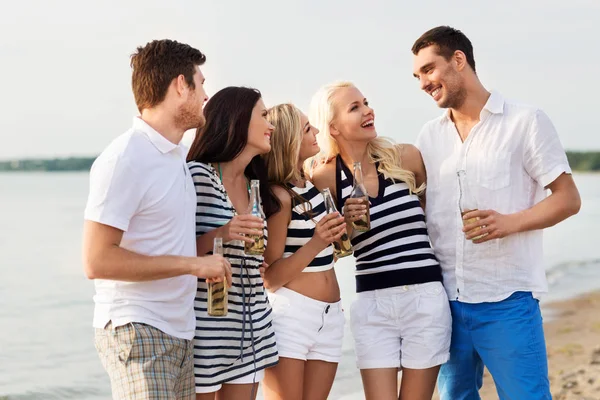 Glada vänner dricka alkoholfri öl på stranden — Stockfoto