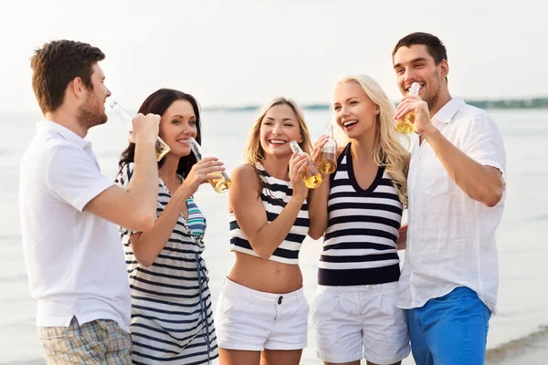 Счастливые друзья пьют безалкогольное пиво на пляже — стоковое фото