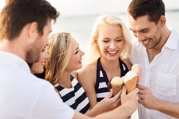 快乐的朋友在海滩上吃冰淇淋 — 图库照片