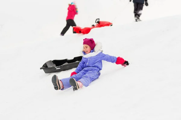 Niños pequeños con trineos en la colina de nieve en invierno —  Fotos de Stock